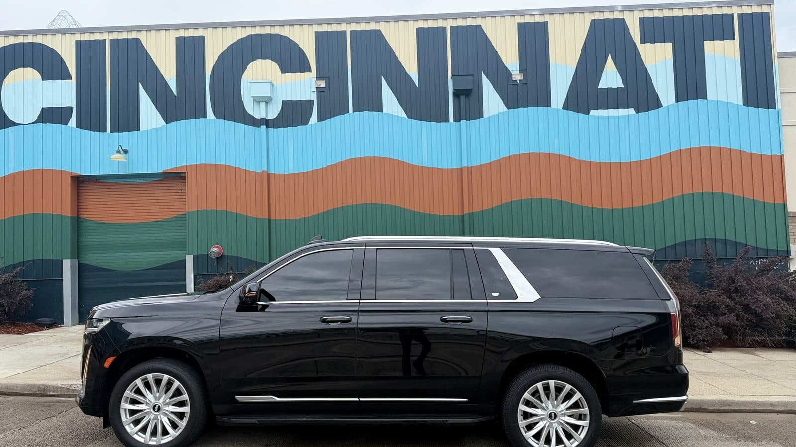 513 Black Car Rental Cadillac Escalade ESV parked in front of the Cincinnati mural downtown